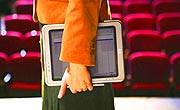 Woman in orange jacket holding HP Compaq tc1100