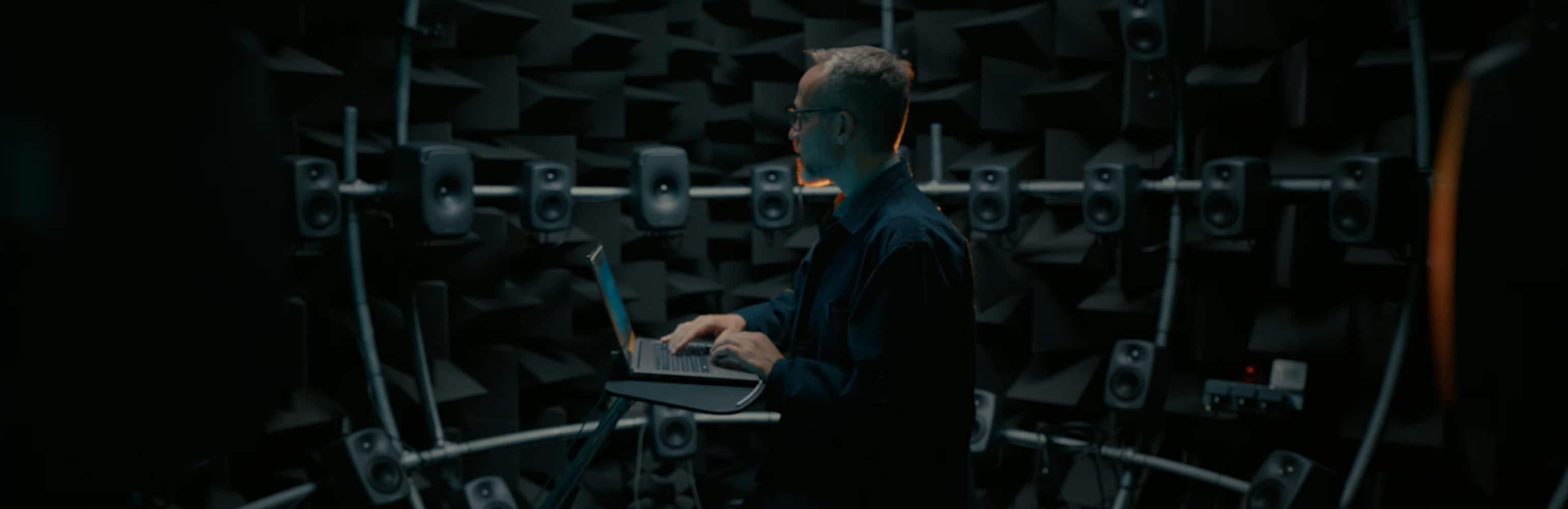 A man checking the sound on many speakers with his HP laptop with Bang & Olufsen.