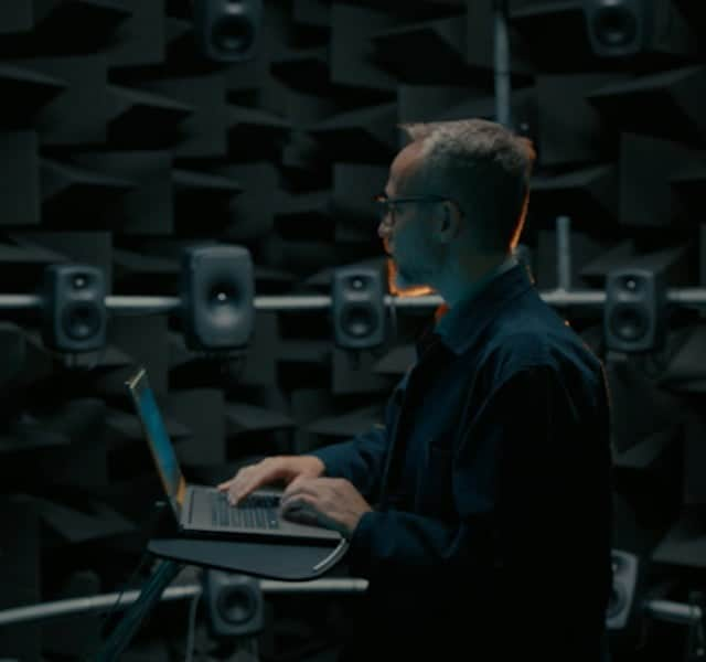 A man checking the sound on many speakers with his HP laptop with Bang & Olufsen.