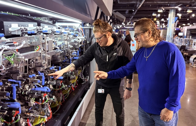 A person pointing at the engine of an HP press