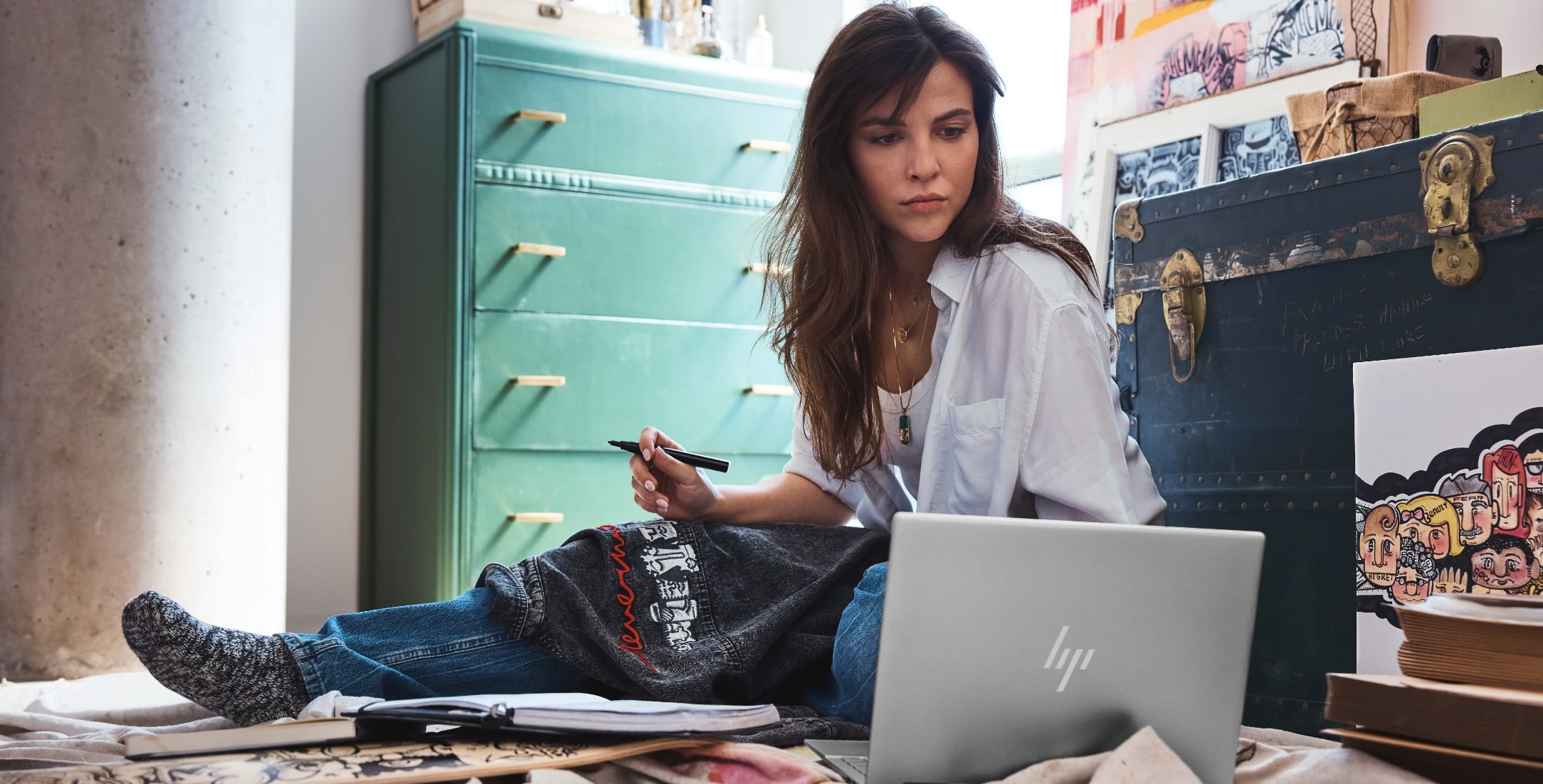 A woman working on some designs while using her HP laptop.