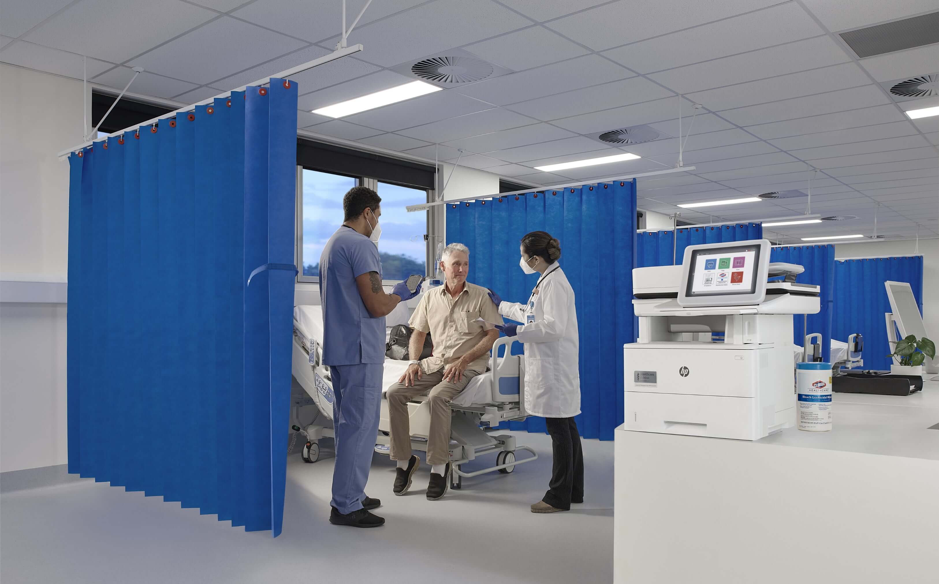 A man at a hospital being attended by 2 doctors