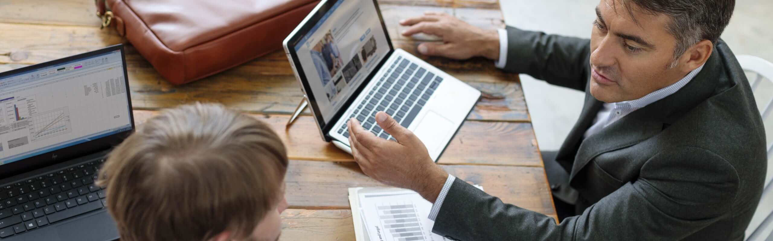 Male teacher with young male student looking at HP EliteBook