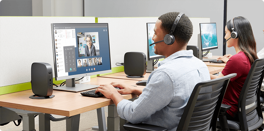 A man and a woman having a virtual conference in their HP Thin Client desktops on their desks.