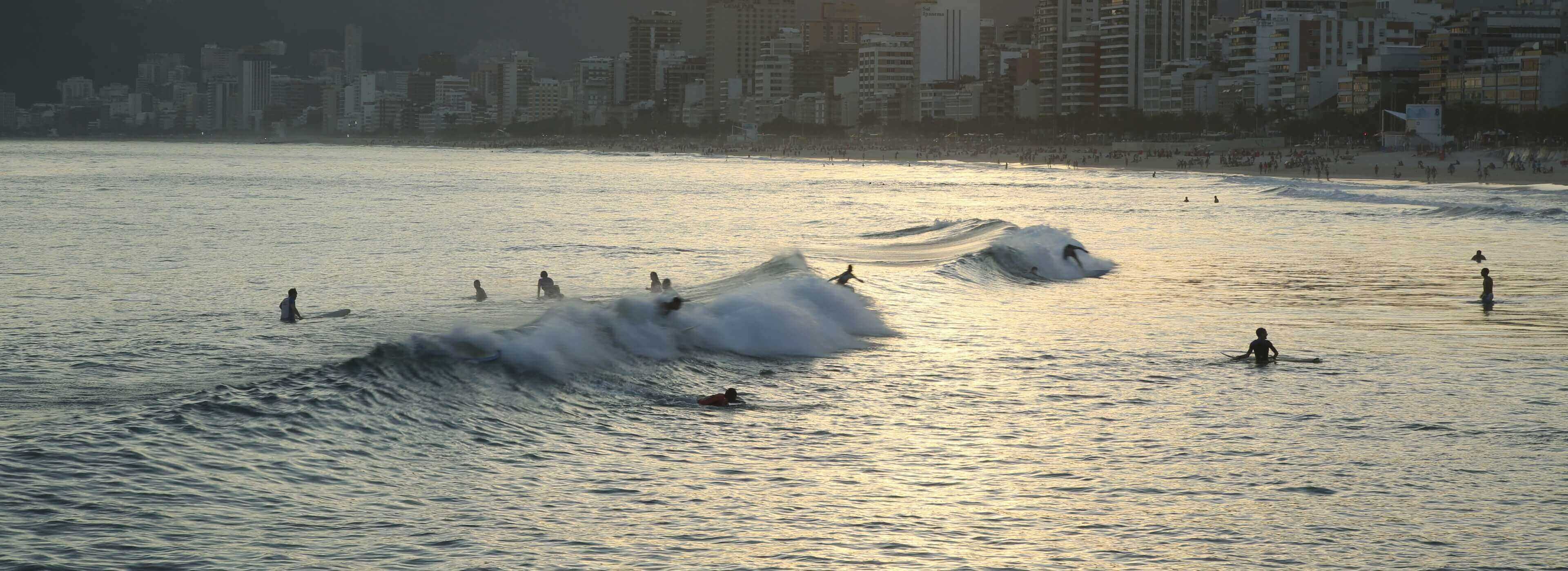 A bunch of surfers enjoying the waves in the beach.