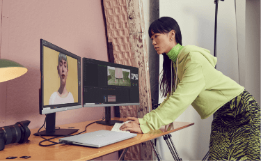 Woman working with devices connected to two HP Monitors