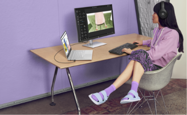 A woman sitting at her desk working with an HP Laptop connected to an HP Monitor