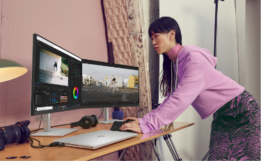 Woman working with devices connected to two HP Monitors