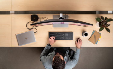 Top view of a man working in front of an HP Ultrawide Curved Monitor