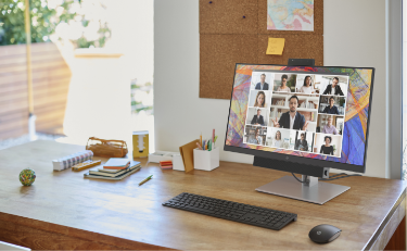 An HP Monitor over desk, video conference call is showing in screen