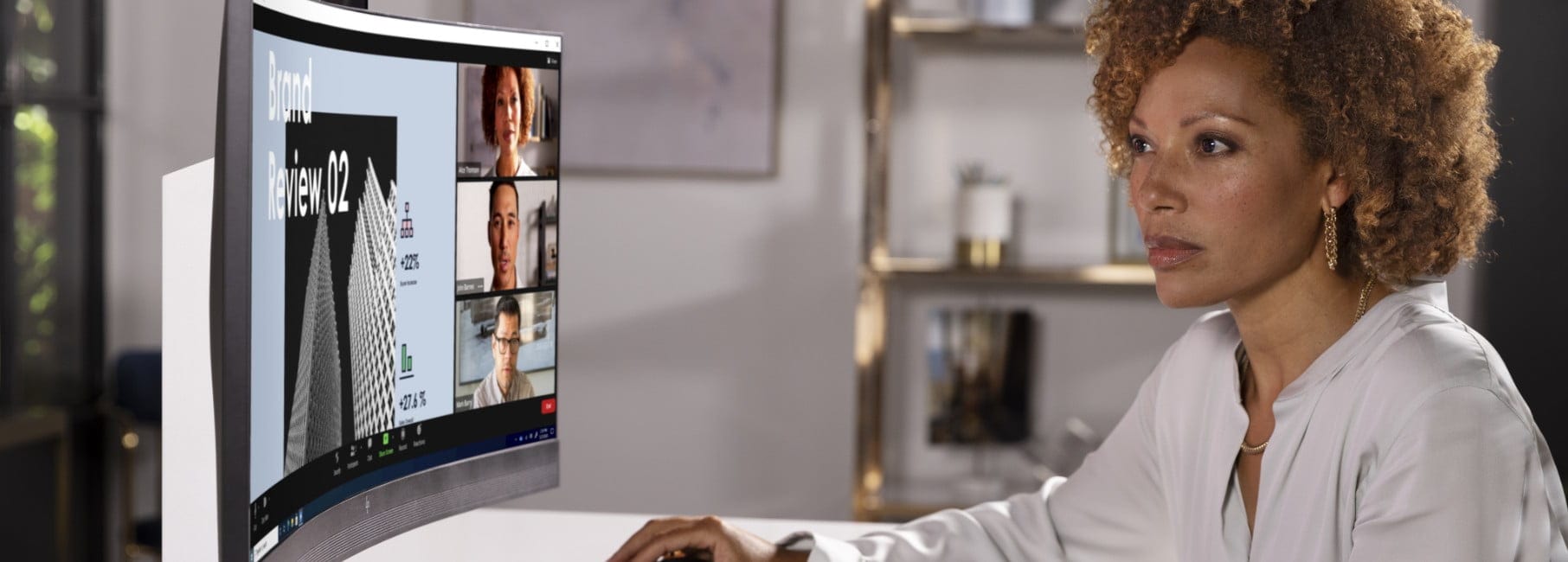 A woman working in front of an HP curved monitor