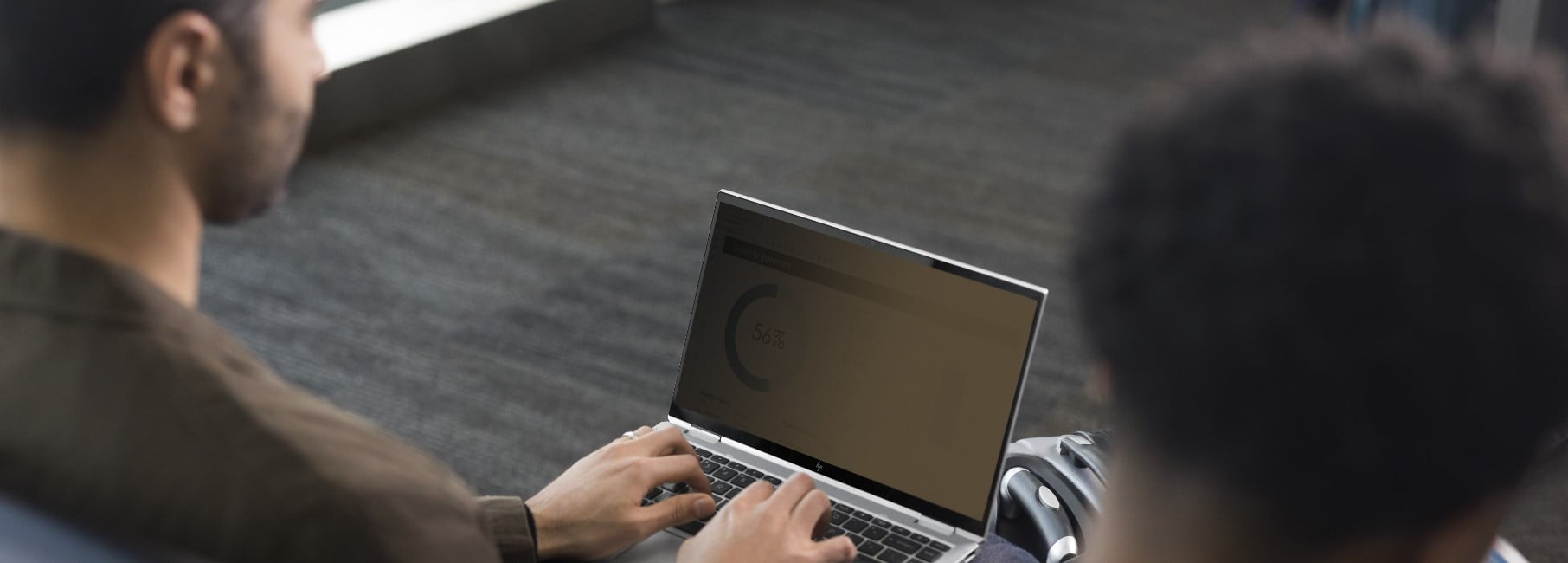 A man uses an HP EliteBook x360 1040 G7 with Sure View reflect.