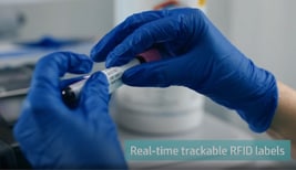 A clinic worker labeling a blood sample using blue globes.