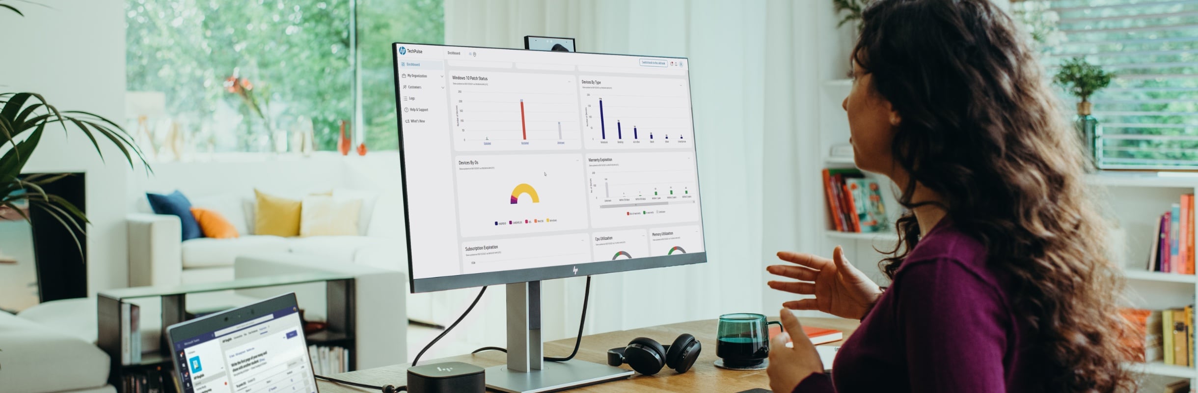 Woman looking at some data on an HP monitor connected to an HP hub and HP laptop