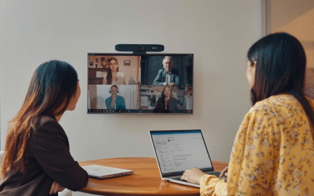 Two women having a virtual conference on an HP laptop using a Poly device