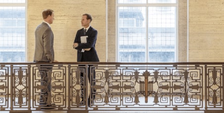 Two men talking in a capital rotunda in a government building