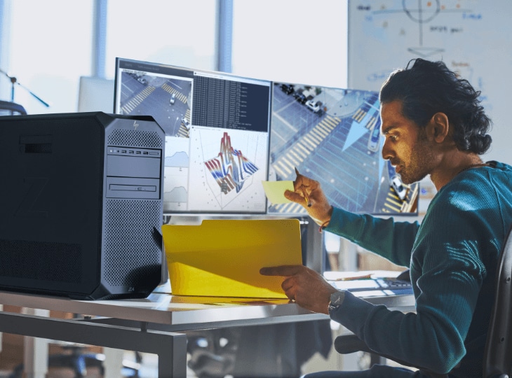 Um homem trabalhando em sua estação de trabalho HP Z Desktop conectada a dois monitores HP Z