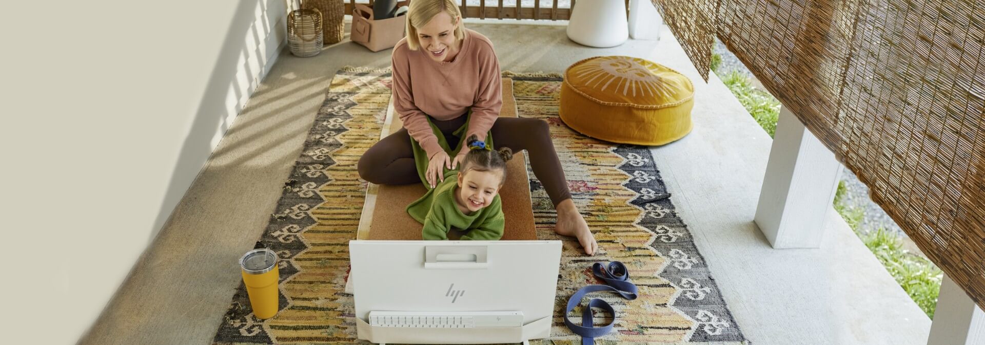 Donna e figlia che si divertono a guardare un PC All-in-One HP Envy.