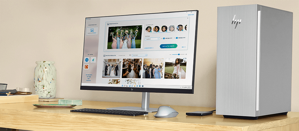 An HP Monitor showing on screen the HP PhotoMatch app, next to the monitor there is an HP Envy Desktop