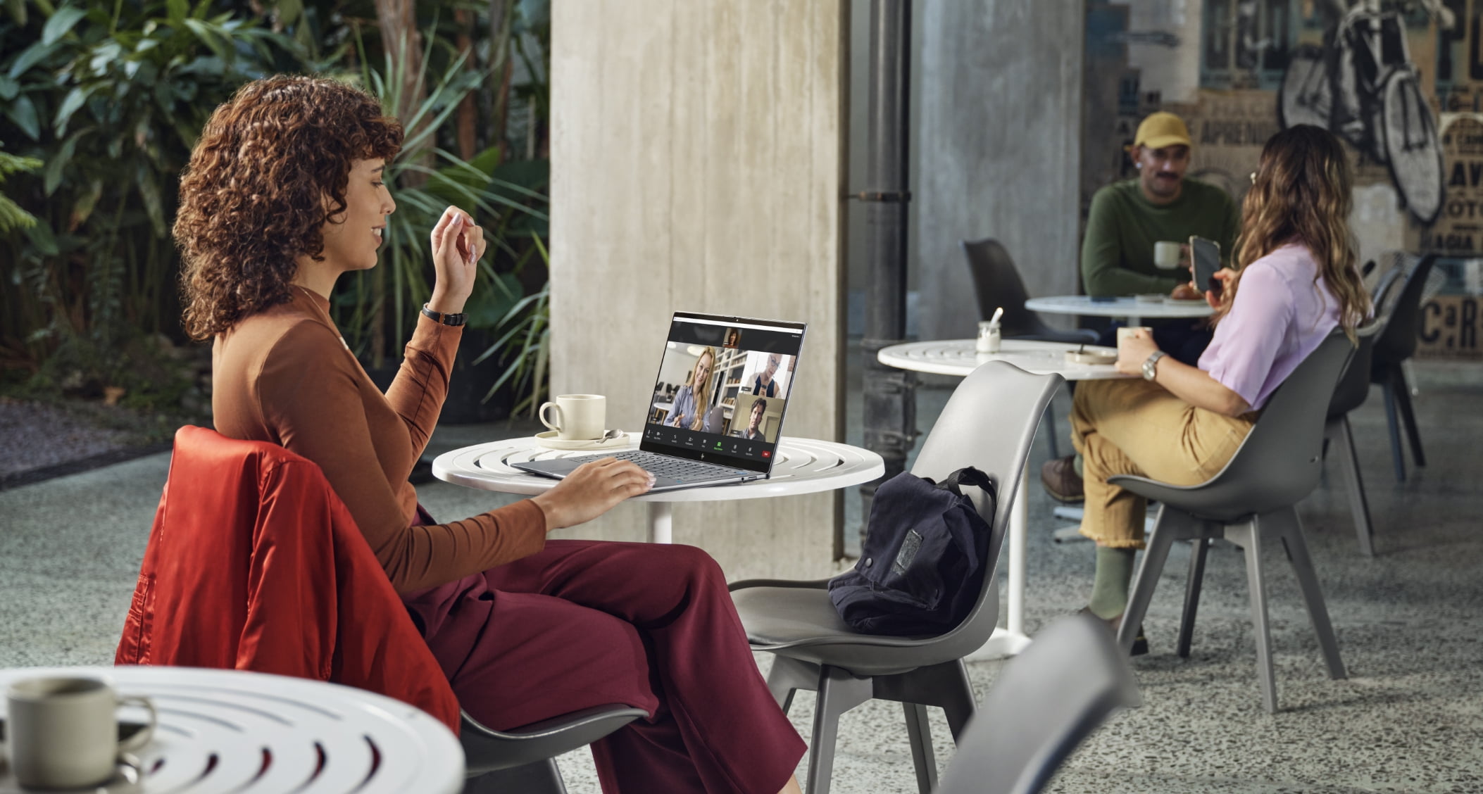 Person at cafe on a video call using the hp omnibook x 14" pc