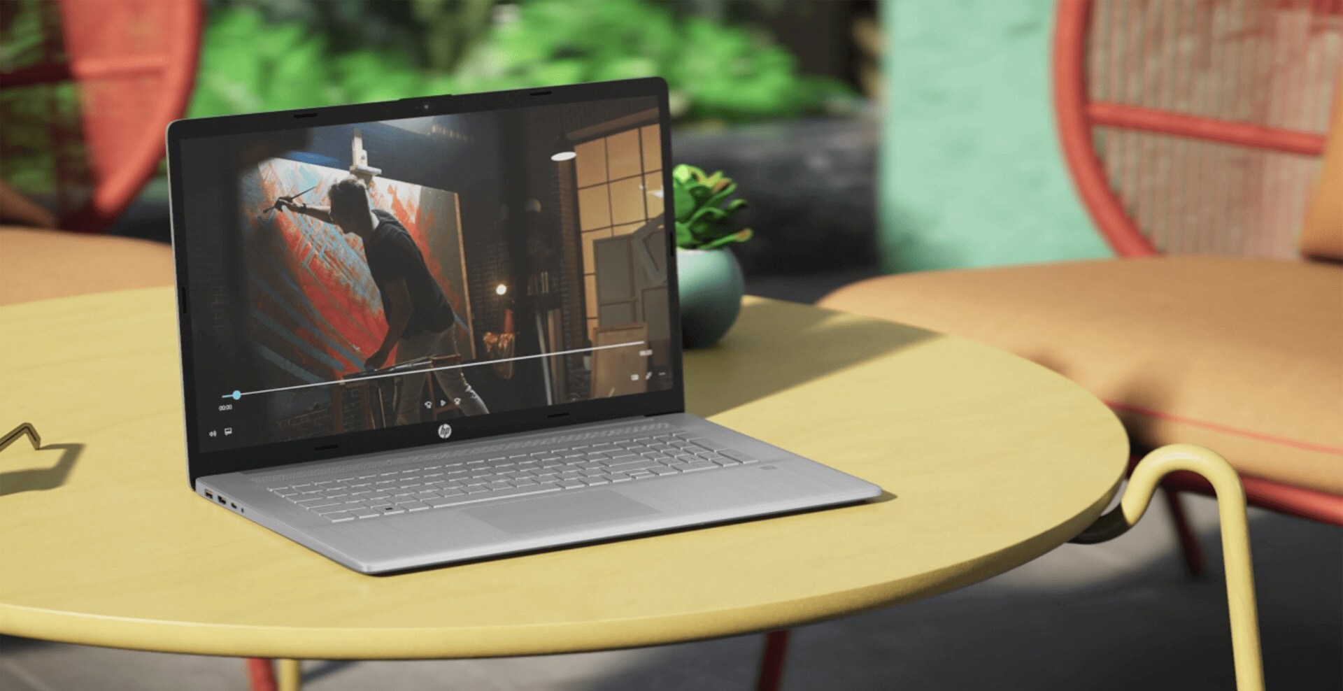 An HP laptop on top of a coffee table showing a video on the screen.