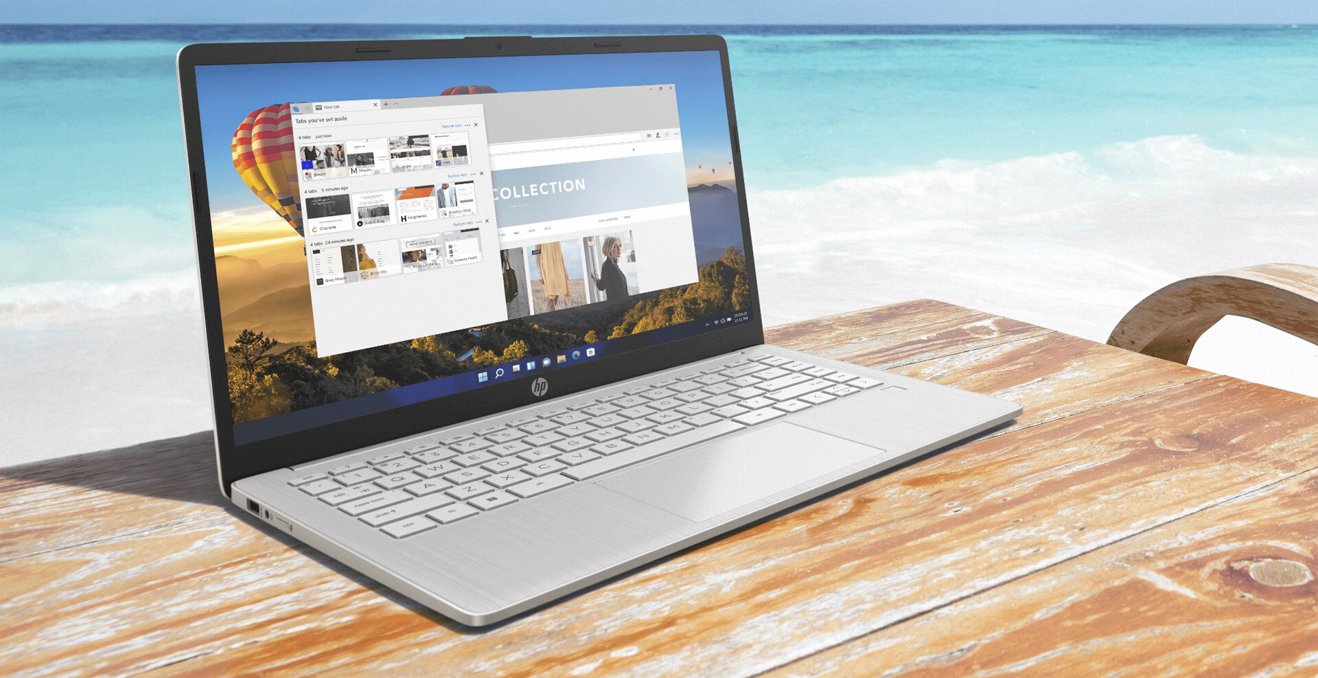 An HP laptop on top of a wooden table in the beach.