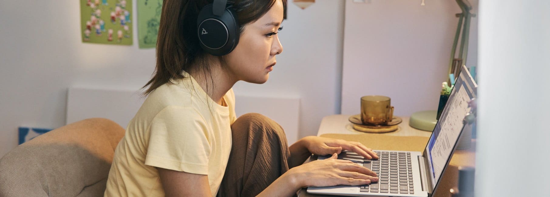 Une personne assise à un bureau portant un casque et utilisant son ordinateur portable HP Pavilion