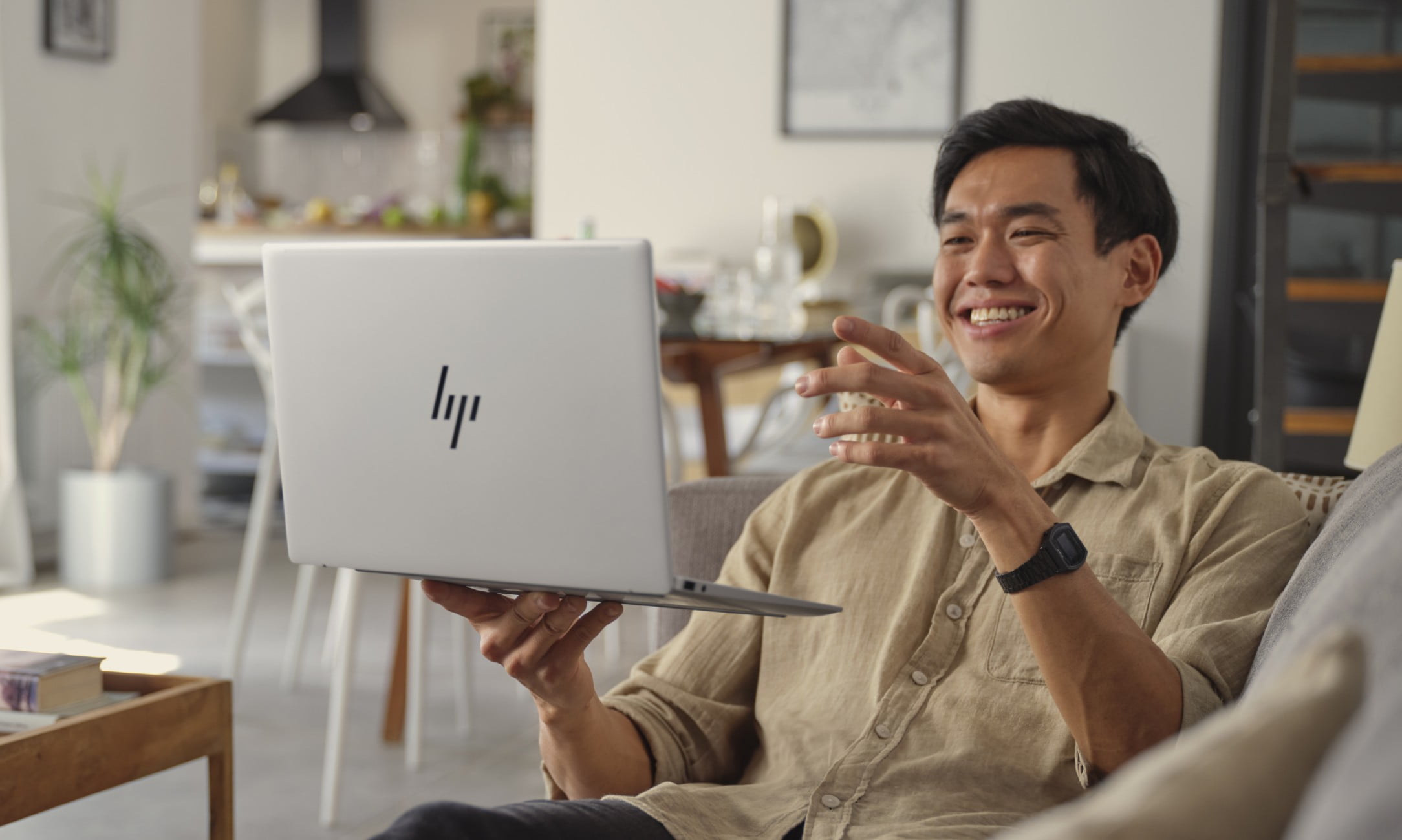 คนที่กำลังเขียนบันทึกขณะตรวจสอบข้อมูลบางอย่างบนแล็ปท็อป HP Pavilion