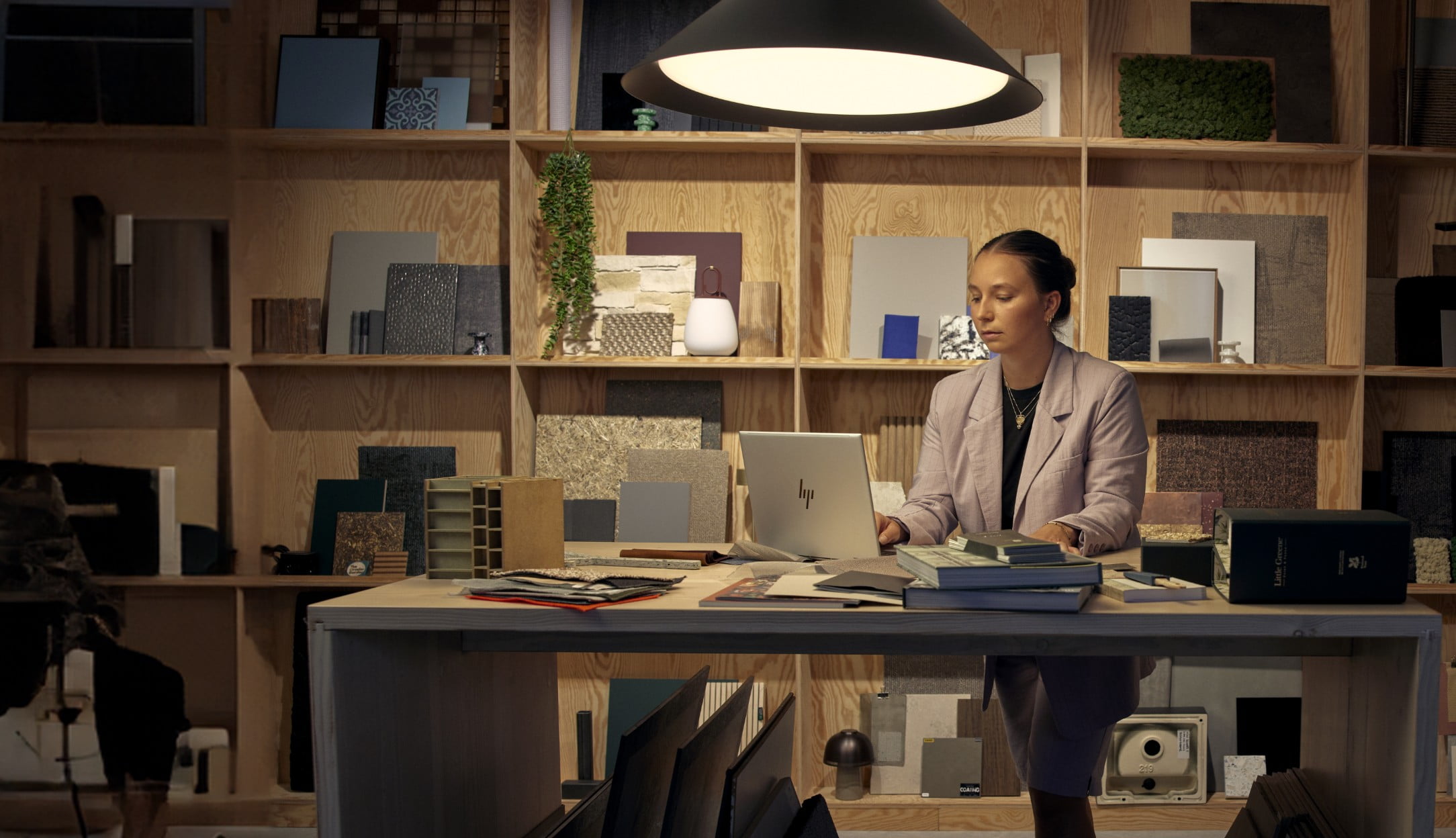 Une femme à un bureau travaillant avec un PC portable HP EliteBook.