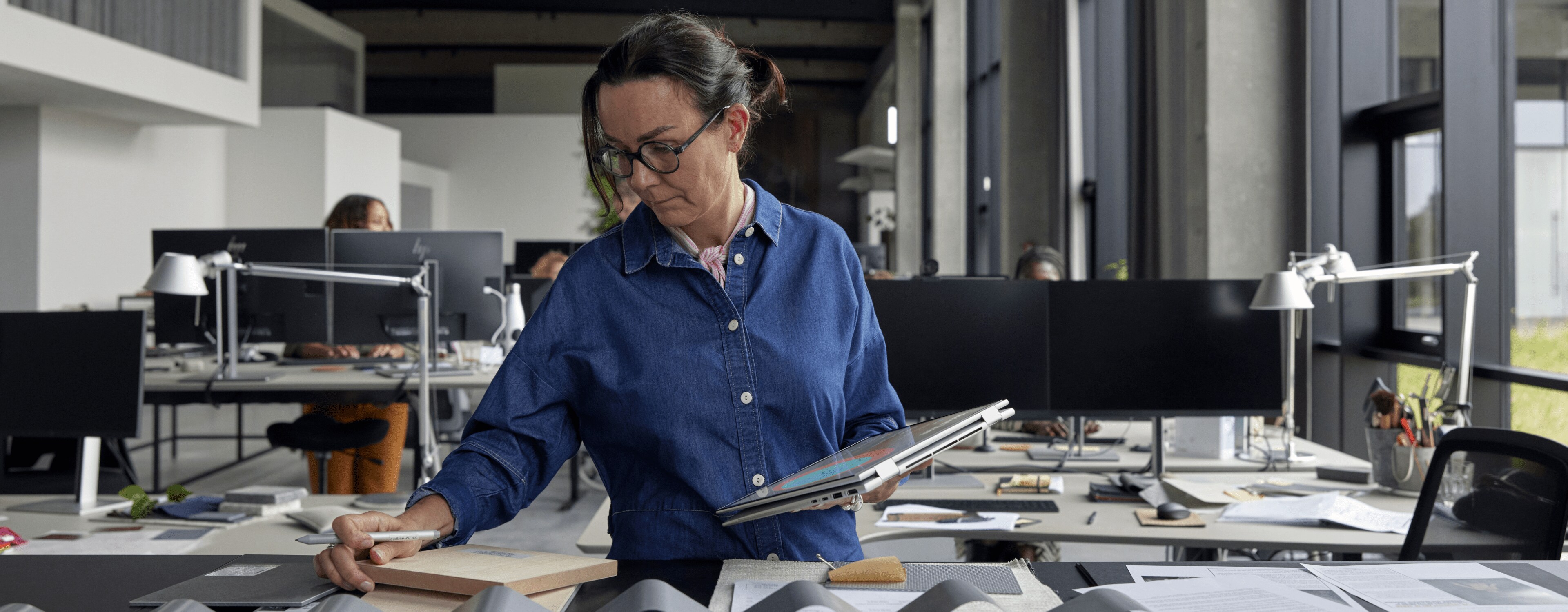 Mujer tomando algunas notas en su HP EliteBook en modo tablet mientras está de pie.