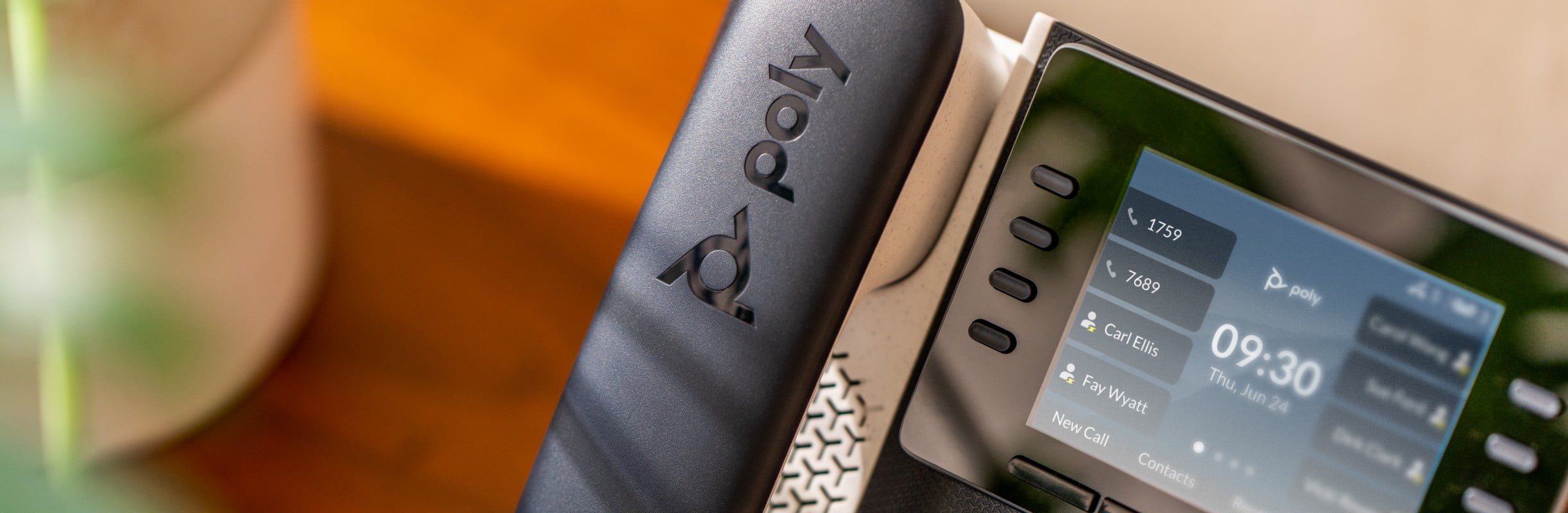 Close up of Poly Edge E350 IP desk phone on a wood credenza, showing multiple lines,menu screen and controls​