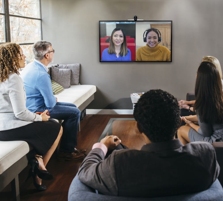 People in medium size conference room during video call using Poly Studio E70 video conferencing camera 