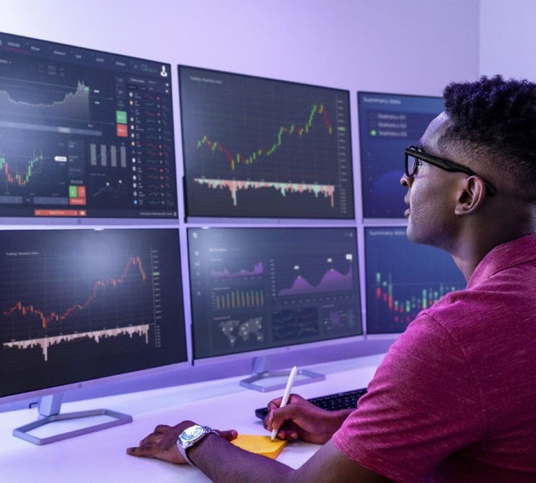 Man looking at several HP monitors showing data visualisations from Poly software and services 