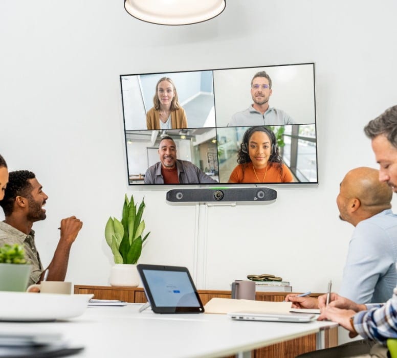 Group of people in conference room using Poly X52 video conferencing system to collaborate with remote colleagues during video call