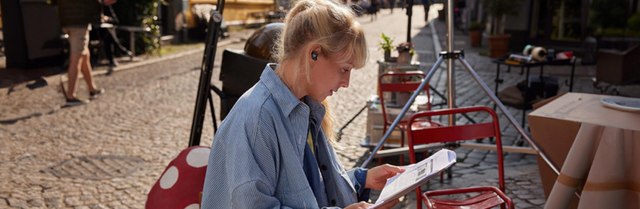 Women sitting outside and wearing Poly Voyager Free 20 earbuds 