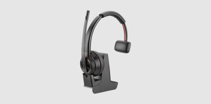 Un micro-casque sans fil DECT de la gamme Poly Savi 8210 Office sur un socle avec une connectivité multiappareil et des commandes de volume