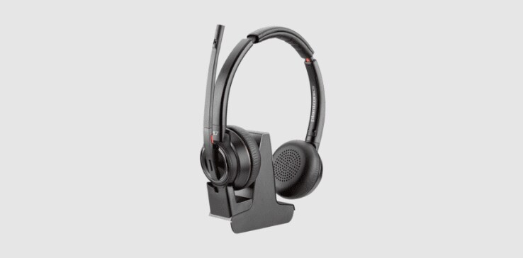 Micro-casque sans fil DECT Poly Savi 8220 Office sur son socle avec connectivité multi-appareils et commandes de volume