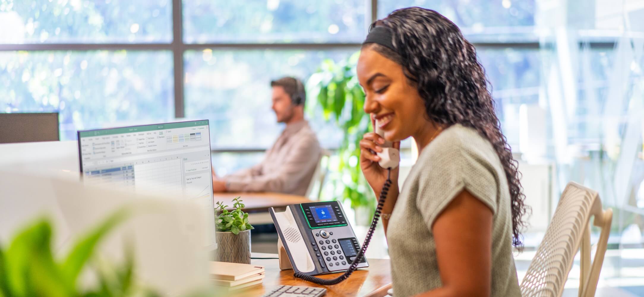 Eine Frau verwendet bei der Arbeit ein Poly Festnetztelefon