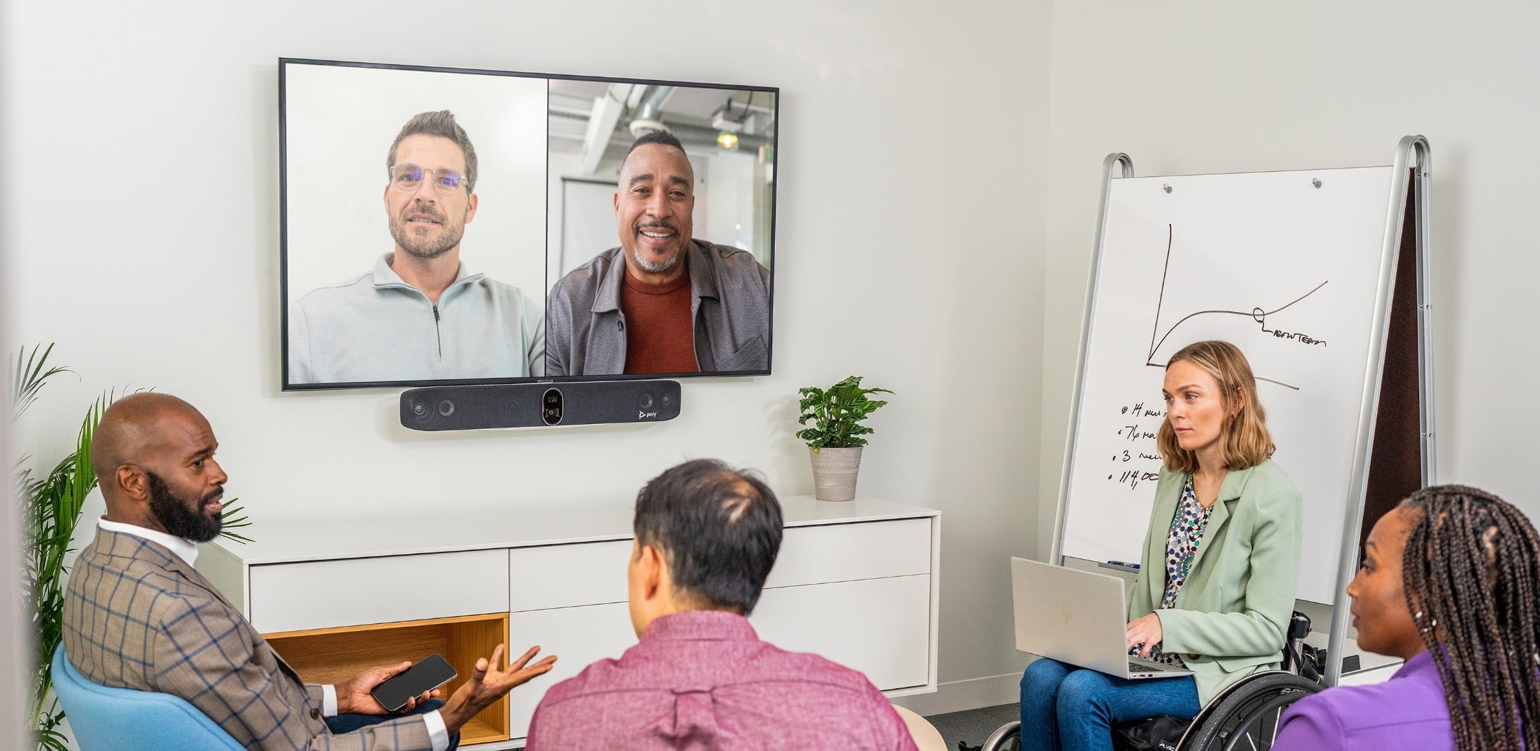 Personas en una sala de conferencia durante una videollamada usando una solución Poly Studio X70 para videoconferencias