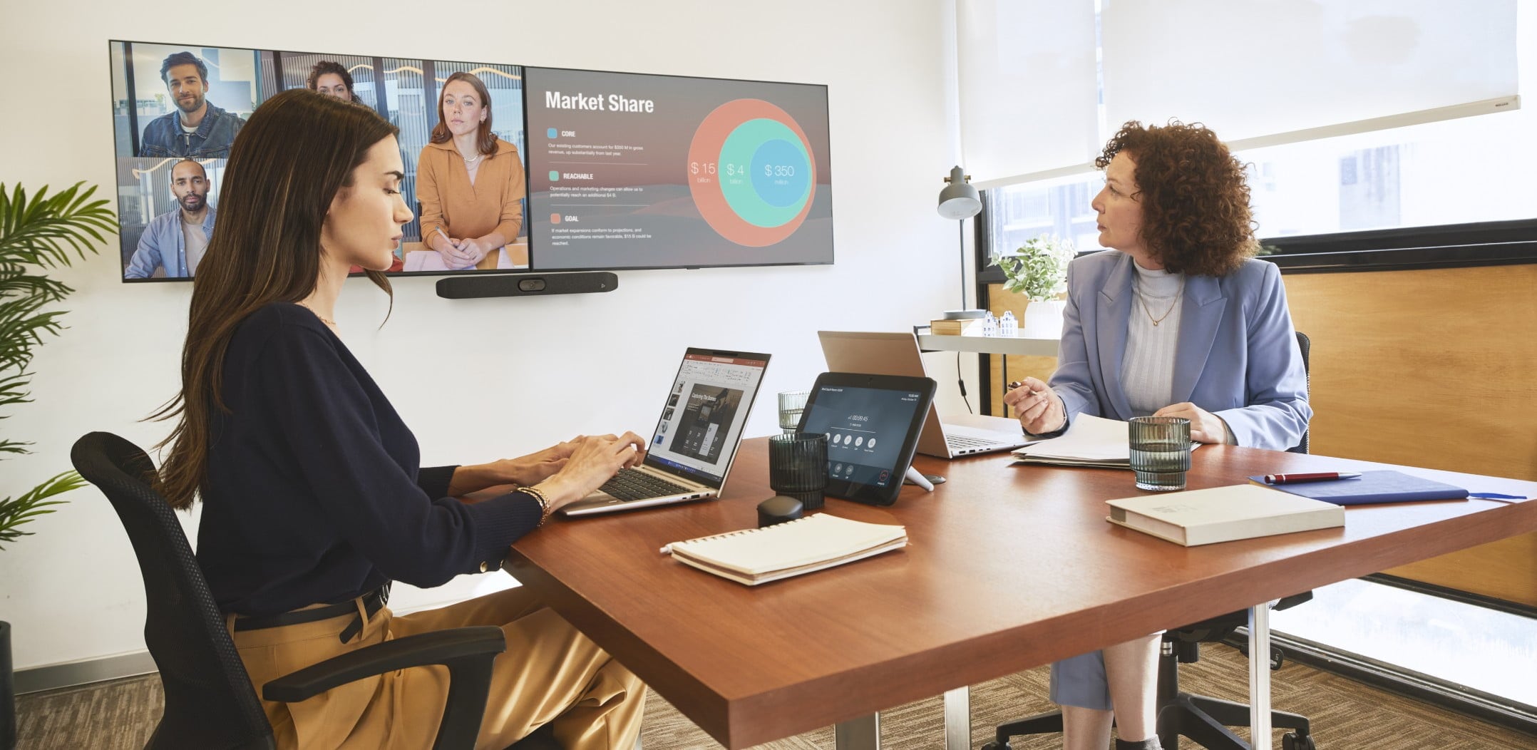 Two people in a small meeting room on a video conference call