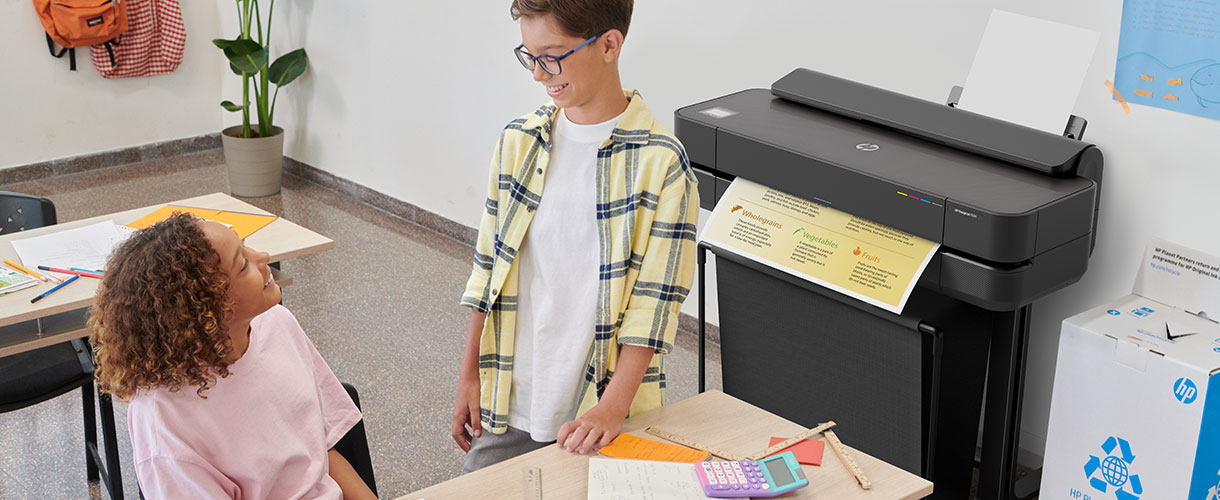 Personas en un aula al lado de un plotter HP DesignJet