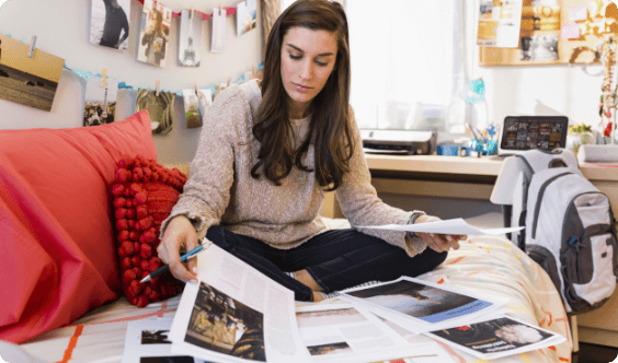 A woman sorting printed papers on a couch