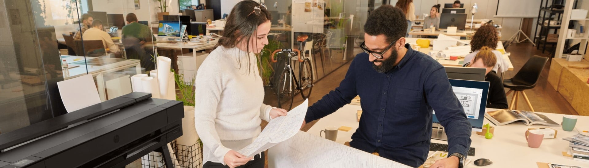 People checking a printed media next to the HP DesignJet T850 plotter in an office