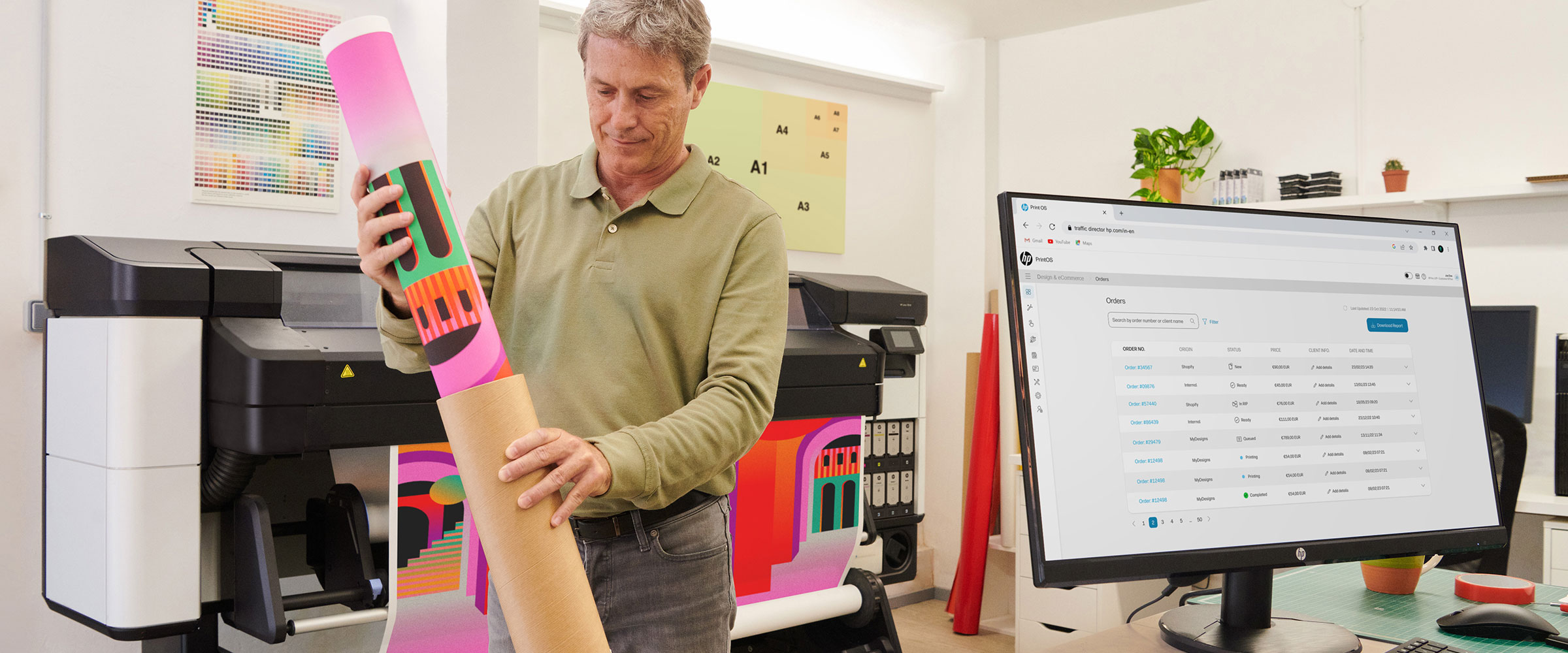 Person checking printing media in front of an HP monitor and an HP Latex printer