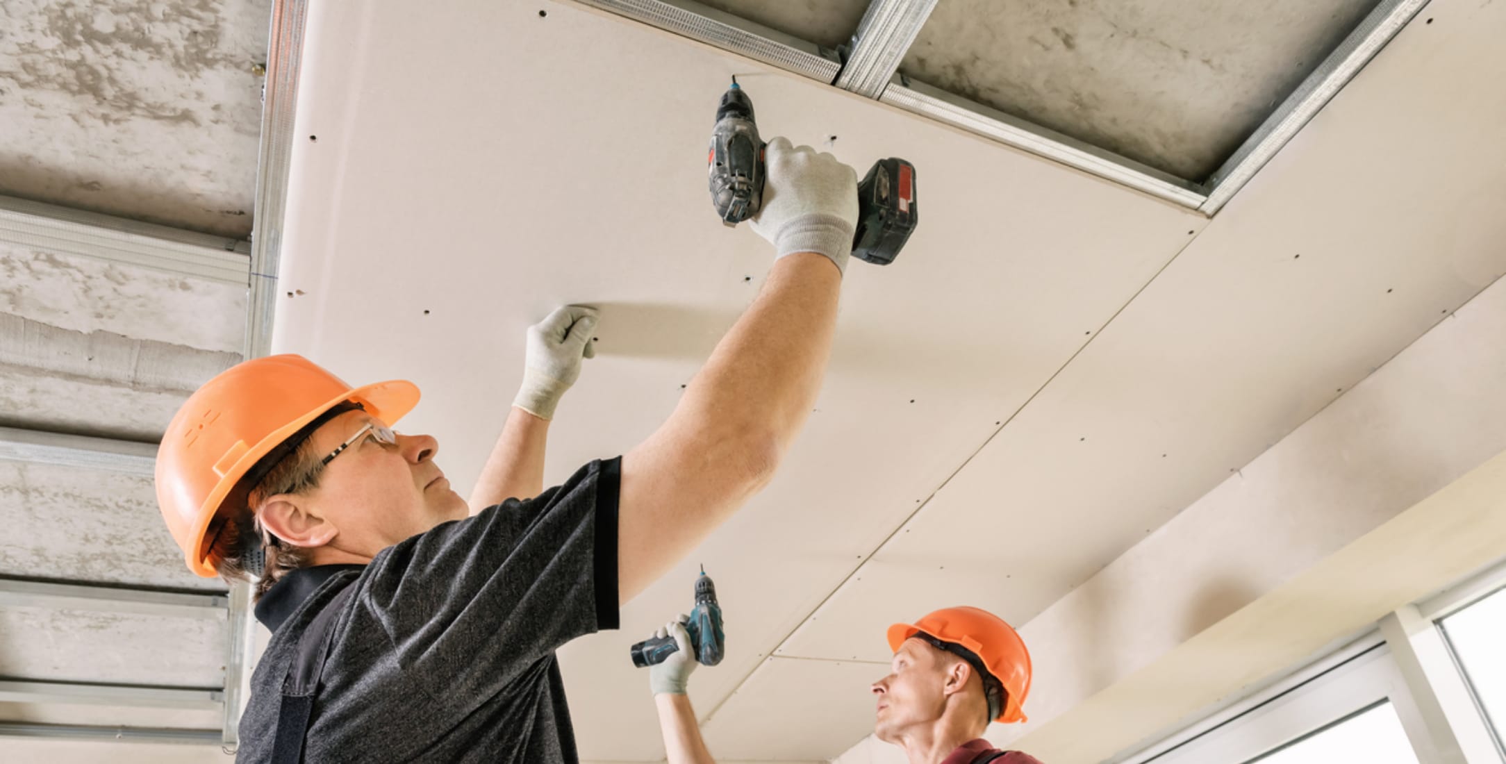 Drywallers installing drywall on the ceiling