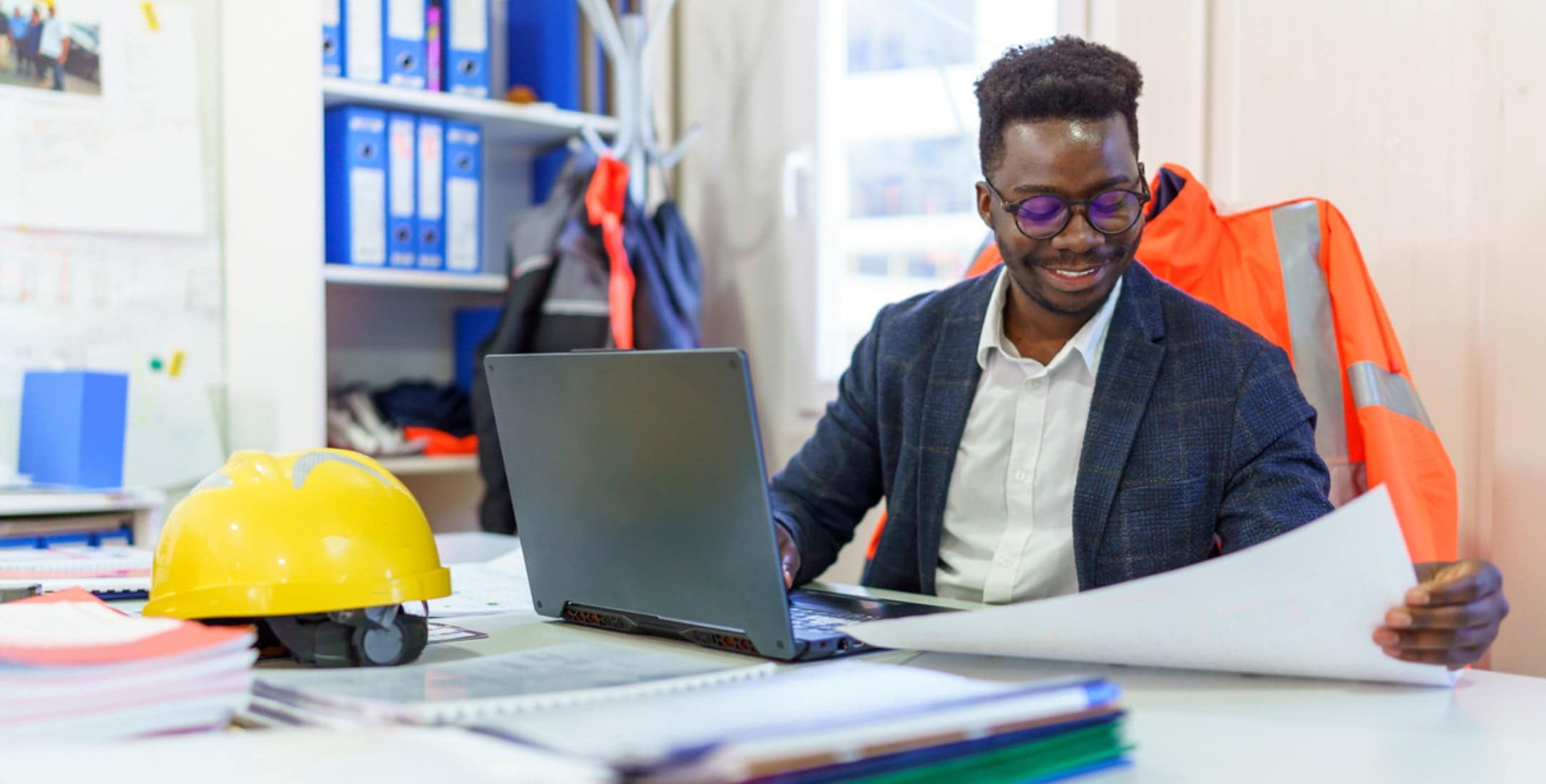 Man reviewing layout plans sitting at a desk