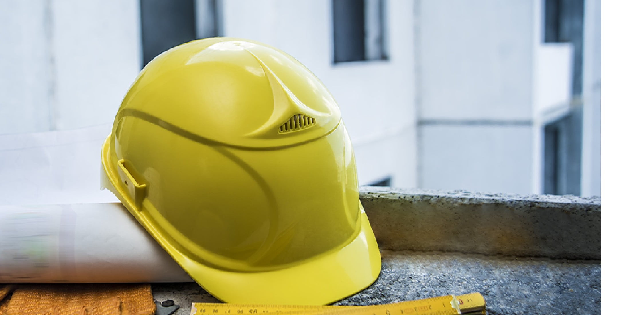 Construction hat sitting on a rolled up blueprint