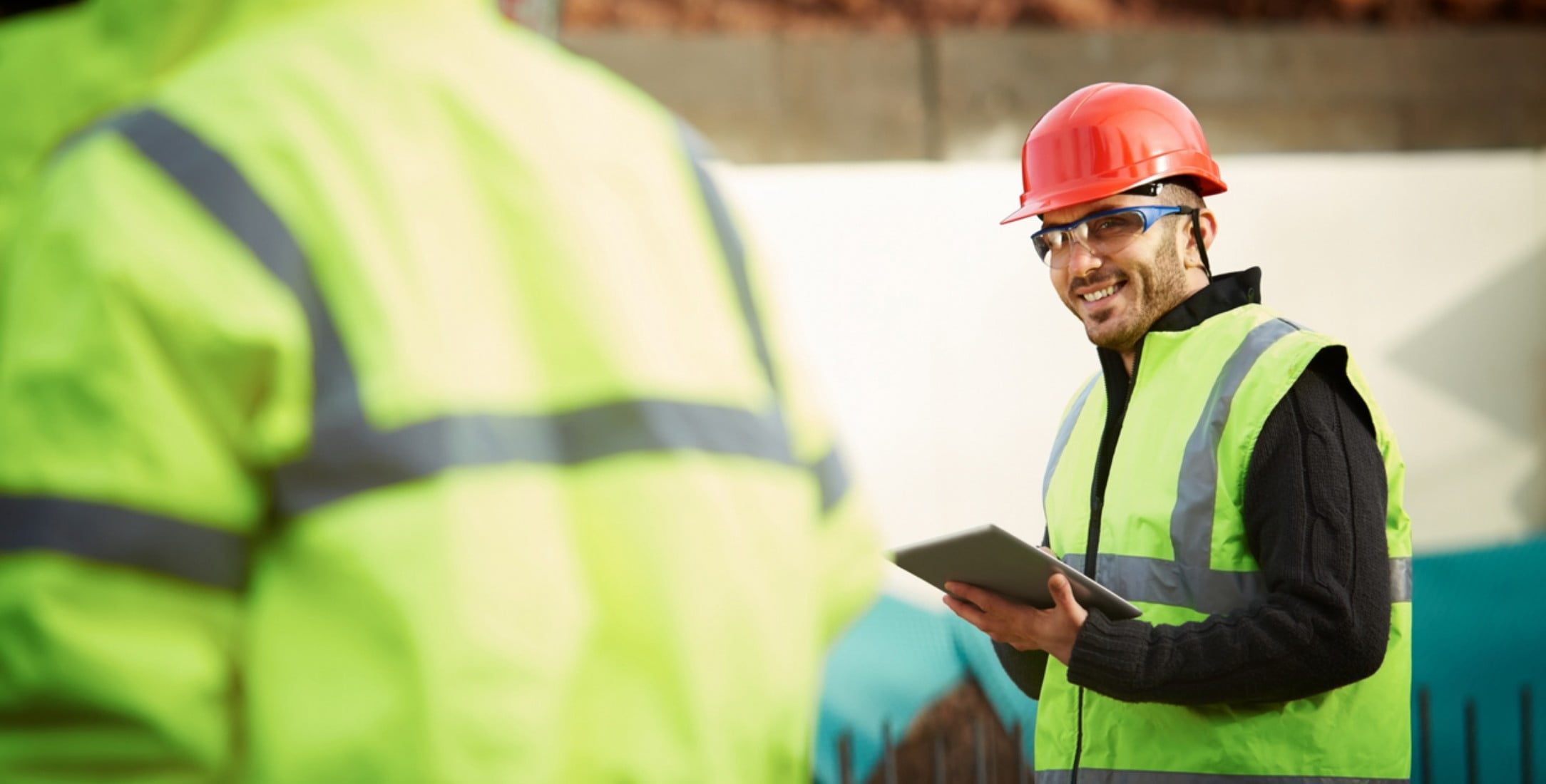 Construction worker holding tablet.