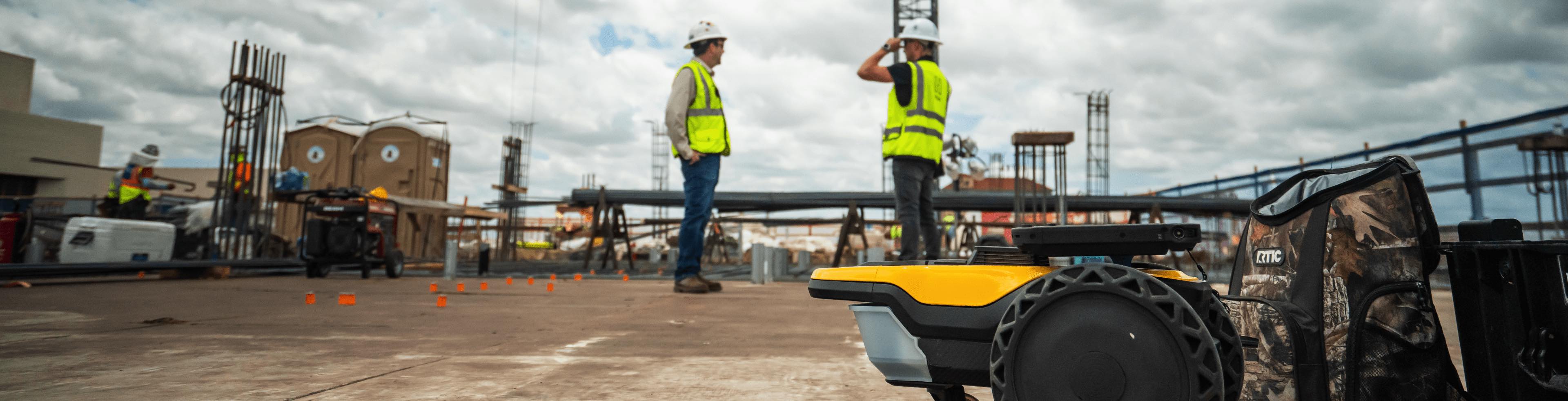 Construction workers on job site with SitePrint robot