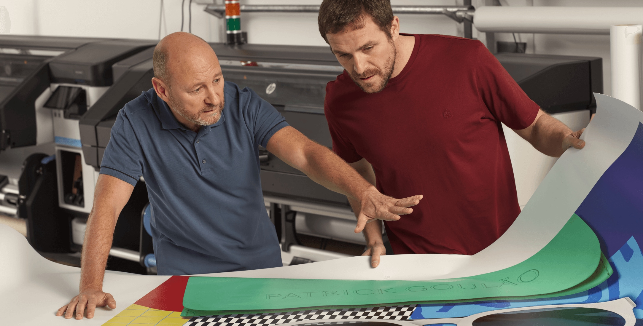 Two men looking at bright large format poster